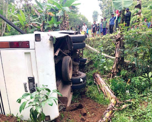 HENDAK BERWISATA: Bus yang mengangkut rombongan dari MTs Annur Sawahan, Turen, ini terguling di Kecamatan Wonosari, kemarin siang (13/8). (Yudhistira/ Radar Malang)