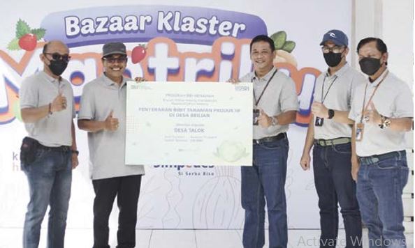 BERDAYAKAN UMKM: Pimpinan Cabang BRI Marthadinata Patar Pandapotan (tiga dari kanan) menyerahkan secara simbolis bibit tanaman produktif kepada Desa Talok, Kecamatan Turen, kemarin. (KIKI EVA/RADAR MALANG)