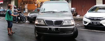 GENJOT PENDAPATAN: Seorang juru parkir (jukir) mengatur kendaraan di ruas Jalan Zainul Arifin, Klojen, Kota Malang, kemarin (14/8). Kawasan di sepanjang jalan ini termasuk parkir tepi jalan.