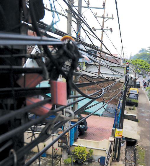 tumpang tIndIh: jaringan kabel fiber optic milik sejumlah provider di kawasan kecamatan pakisaji, kabupaten malang.  (darmono/radar malang)
