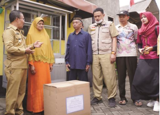 SALURKAN BANTUAN: Wakil Wali Kota Batu Punjul Santoso (kiri) menyaksikan penyerahan bantuan peralatan kepada warga Kelurahan Temas, kemarin (30/8). (ALIFIANI/RADAR BATU)