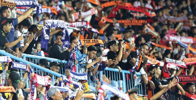BIKIN SEJARAH BARU: Aremania berbagi tribun dengan Jakmania, beberapa waktu lalu. Minggu sore (11/9), mereka akan berbagi tempat di Stadion Kanjuruhan dengan pendukung Persib Bandung. (Darmono/ Radar Malang)