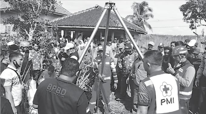 MUSIBAH: Tim Tagana dan PMI Kabupaten Malang Mengevakuasi jenazah Mutiah yang tercebur sumur di Desa Karangsari, Kecamatan Bantur, Kabupaten Malang, kemarin pagi (9/9). (TAGANA KABUPATEN MALANG FOR RADAR MALANG)