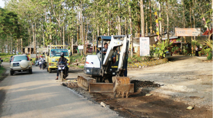 DIBENAHI: Pekerja menggunakan mini ekskavator untuk peningkatan jalan Wonokerto-Bantur dengan nilai proyek sekitar Rp 1,5 miliar. DARMONO/RADAR MALANG