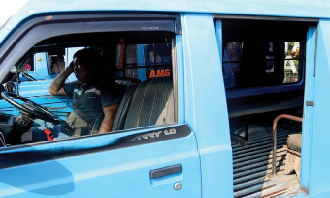 MENANTI LEGALITAS TARIF: Salah satu sopir angkot menunggu penumpang di perempatan Gadang, kemarin. (Darmono/ Radar Malang)