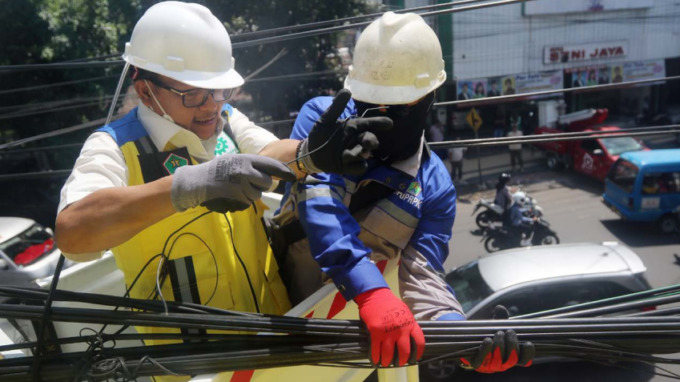 SIAPKAN PRODUK HUKUM: Wali Kota Malang Sutiaji (kiri) ikut melakukan penataan kabel di Jalan Kawi, Kecamatan Klojen, kemarin siang (14/9). Menaiki mobil crane, dia melakukannya di ketinggian sekitar empat meter. Kegiatan itu jadi bagian dari program berna