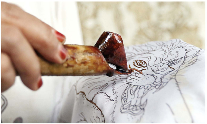 BATIK SINGO EDAN: Perajin batik tulis organik di Kecamatan Kedungkandang membubuhkan pewarna alami pada kain yang sebelumnya telah diolah. (DARMONO/RADAR MALANG)