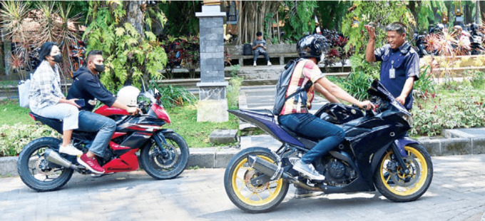 JAGA KETENANGAN: Petugas keamanan Universitas Brawijaya menyosialisasikan larangan penggunaan knalpot brong kepada mahasiswa yang memasuki kampus tersebut. Larangan yang sama juga berlaku untuk dosen maupun pengunjung. (darmono/ radar malang)