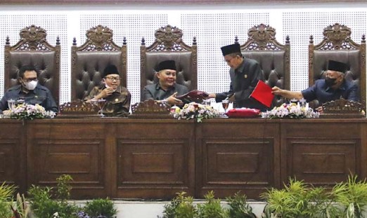SIDANG PARIPURNA: Ketua DPRD Kota Malang I Made Riandiana Kartika (tengah) menerima draf pandangan umum fraksi dari Wakil Ketua DPRD Abdurrachman, kemarin. (Suharto/Radar Malang)