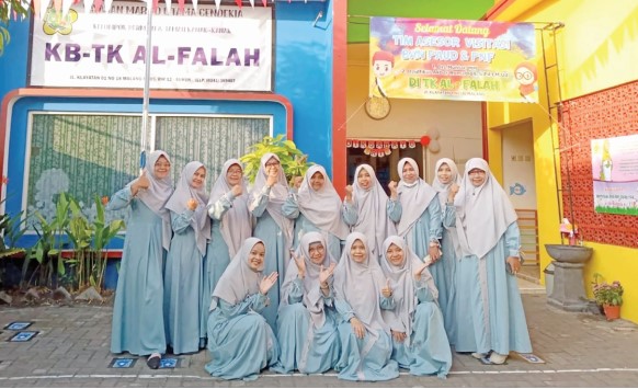 KOMPAK : Kepala TK Al-Falah Lusi Handayani SPd (tengah) bersama guru dan staf saat Akreditasi sekolah beberapa waktu lalu. (TK Al-Falah For Radar Malang)