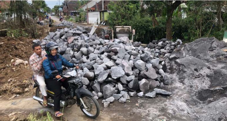GANTIAN: Pengendara sepeda motor melewati jalan darurat di samping jembatan yang sedang dibangun. (YUDISTIRA/RADAR MALANG)