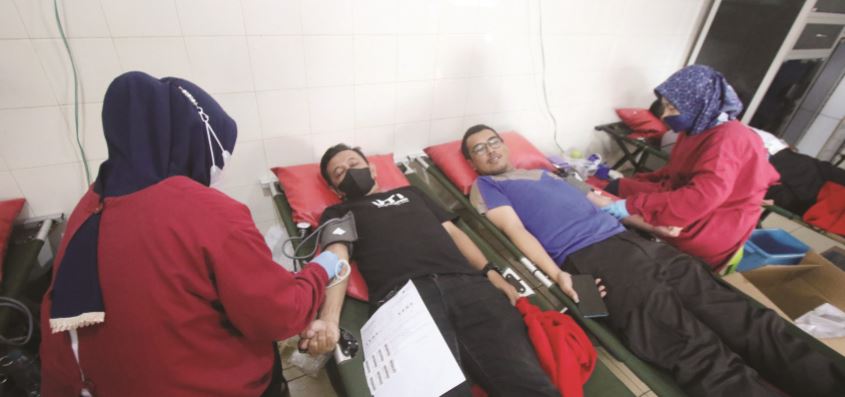 AMANKAN STOK: Nakes melayani peserta donor darah IJTI Malang Raya di markas PMI Kabupaten Malang. (YUDHISTIRA/RADAR MALANG)
