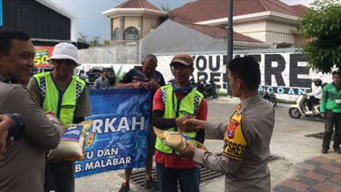 BERBAGI: Aremania Batu membagikan sembako kepada juru parkir, Jumat (30/9) untuk menyambut pertandingan Arema vs Persebaya. (NADA DHUHA/RADAR BATU)