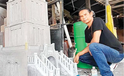 TELATEN: Agus Sujito bersama miniatur Jam Gadang karyanya yang berukuran jumbo. Detail karya miniatur itu dibuat mirip dengan aslinya. (AFIFAH RAHMATIKA FURZAEN/RADAR MALANG)