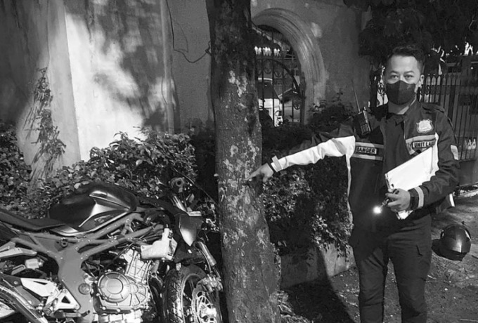 KURANG KONSENTRASI: Polisi menunjukkan motor Honda CBR yang masih terjepit di antara pohon dan pembatas jalan pada kecelakaan yang terjadi di Jalan Mayjen Panjaitan, Sabtu dini hari (22/10). RELAWAN MALANG RAYA FOR RADAR MALANG