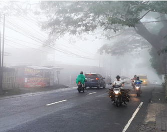 HALANGI PANDANGAN: Kabut tebal yang turun di Kota Batu membuat jarak pandang pengendara di Jalan Patimura semakin pendek. (AFIFAH RAHMATIKA/RADAR BATU)