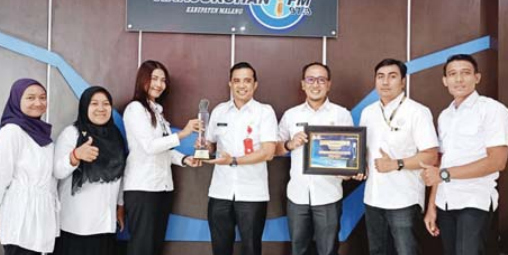 BIKIN BANGGA: Kepala Dinas Kominfo Kabupaten Malang Ricky Meinardhy (tengah) bersama Kabid Komunikasi Johan Dwijo Saputro (tiga dari kanan) dan tim Radio Kanjuruhan menunjukkan trophy Terbaik 1 Radio Peduli Bencana. NENY FITRIN/RADAR KANJURUHAN