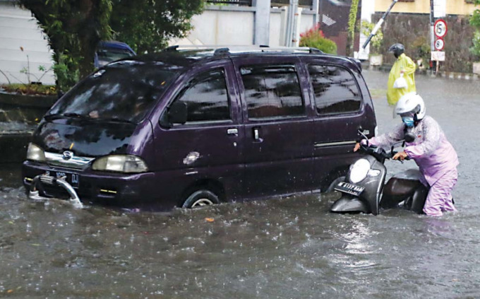 AKIBAT BANJIR. Pengendara menuntun sepeda motor yang terendam genangan air di Jalan Dieng, beberapa waktu lalu.