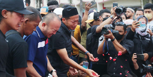 SEMUA BERDUKA: Tim pelatih, pemain, dan official Arema FC melakukan tabur bunga di patung singa di area luar Stadion Kanjuruhan, Kabupaten Malang, kemarin pagi (3/10). (DARMONO/RADAR MALANG)