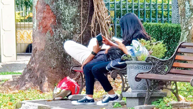 TAK PANTAS: Seorang lelaki tampak rebahan pada perempuan di kursi Jalan Ijen. (SUHARTO/RADAR MALANG)