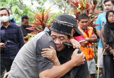 DUKA MENDALAM: Arifin (kanan), ayah Farzah Dwi Kurniawan, dipeluk warga setelah menyelesaikan pemakaman di TPU Sudimoro, Kota Malang Senin (24/10). (SUHARTO/RADAR MALANG)