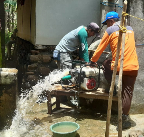DAMPAK BANJIR : Petugas Desa Tambakrejo, Kecamatan Sumbermanjing Wetan menguras sumur salah satu warga. HANIFUDIN MUSA/RADAR MALANG
