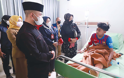 BELASUNGKAWA: Wali Kota Batu Dewanti Rumpoko (dua dari kanan) dan Ketua DPRD Kota Batu Asmadi (berpeci) mengunjungi korban tragedi Kanjuruhan di RS Hasta Brata, Senin (3/10). (DISKOMINFO KOTA BATU FOR RADAR BATU)