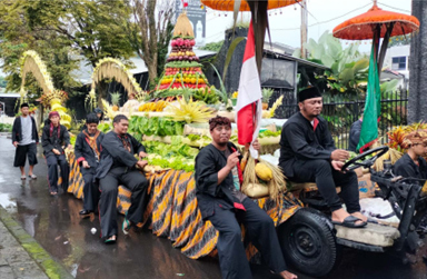HASIL BUMI: Warga Desa Songgokerto mengarak tumpeng yang terbuat dari hasil bumi untuk diarak dalam acara Sedekah Bumi yang digelar kemarin (15/11). (KHUSNUL KHOTIMAH/RADAR BATU)