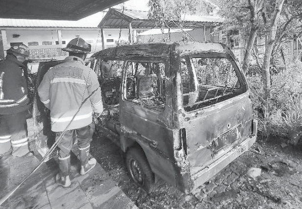 HANGUS 90 PERSEN: Petugas Damkar menuntaskan pemadaman api yang membakar mobil Daihatsu Zebra milik guru SMK Arjuna 2 kemarin pagi (9/11). POLSEK BLIMBING FOR RADAR MALANG