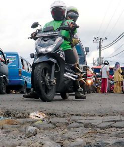 TAK TAHAN LAMA: Kondisi jalan rusak di area Pasar Gadang yang setiap hari dilintasi sejumlah kendaraan. Padahal, belum setahun di jalan itu telah dilakukan perbaikan.