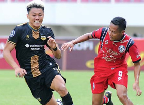 BUTUH TIGA BULAN: Feby Eka Putra (kiri) berusaha menghindar dari kejaran Evan Dimas. Di laga itu, dia hanya bermain 15 menit karena mengalami cedera