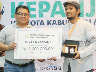FILOSOFI AIR : Wismu Sadono (kanan) menerima hadiah dan penghargaan dari Direktur Jawa Pos Radar Malang Tauhid Wijaya sebagai pemenang juara Harapan 1.
