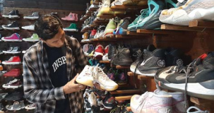 TENGAH MENCARI: Salah satu pembeli tengah memilih sepatu  bekas berbagai merek di AB Bundle Shoes.