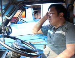 CARI PENUMPANG: Seorang sopir angkot bersantai sambil menunggu penumpang dari Pasar Induk Gadang (PIG).