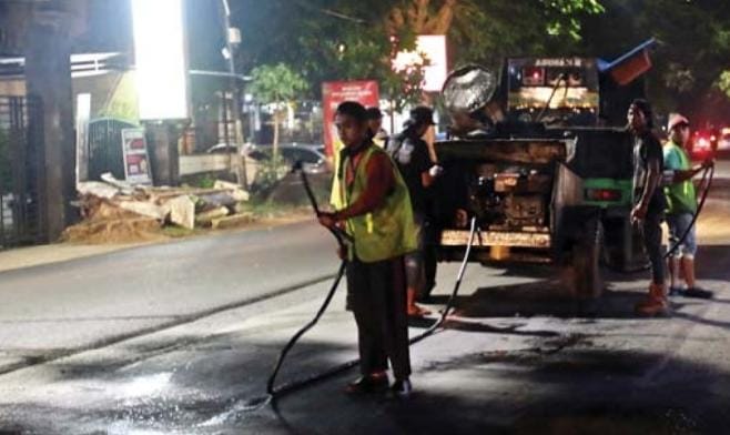 MULUS: Alat berat diterjunkan untuk menambal lubang jalan di kawasan Jalan Kolonel Sugiono, beberapa waktu lalu. - DARMONO/RADAR MALANG