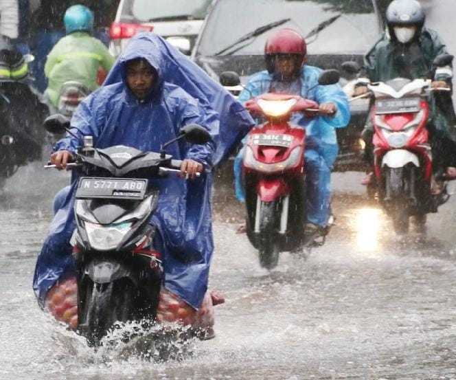 BANJIR: Air hujan meluber di Jembatan Muharto, Kecamatan Kedungkandang kemarin siang (23/12). Menurut BPBD saluran drainase di sana kerap tersumbat