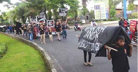 TURUN JALAN: Ratusan Aremania masih menyuarakan keadilan pascatragedi Kanjuruhan di Jalan Veteran kemarin siang (11/12). Dalam aksinya mereka membawa spanduk dan keranda.