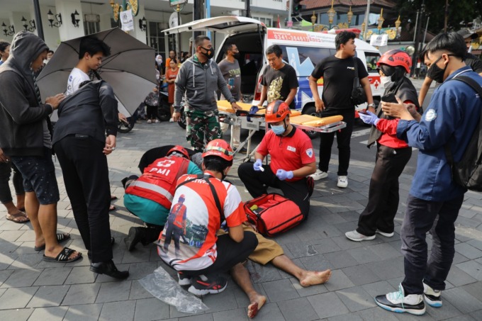 TERLUKA: Petugas PMI memeriksa korban kecelakaan di Simpang Rajabali sebelum membawanya ke RSSA kemarin sore (7/12).