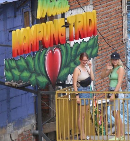 SPORT BARU: Dua wisatawan asing menikmati indahnya spot foto di Kampung Tridi, RW 12 Kelurahan Kesatrian, Kecamatan Blimbing, kemarin (27/12).