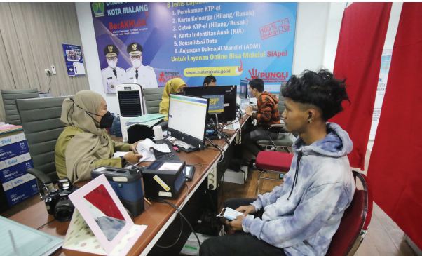 TERTIB ADMINDUK: Staf Dispendukcapil Kota Malang melayani warga yang mengurus e-KTP di Mal Pelayanan Publik (MPP), kemarin. Jumlah pemohon yang bisa diproses kini dibatasi 100 orang per hari.