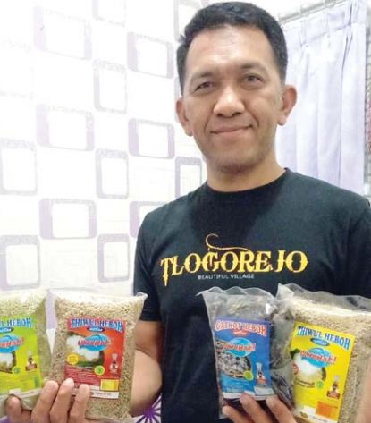 BERDAYAKAN PETANI: Yosea Suryo Widodo menunjukkan gatot dan tiwul instan yang sudah dikemas rapi. Tiap bulan ada ribuan bungkus yang dia kirim ke luar negeri. ( Photo By Radar Malang )