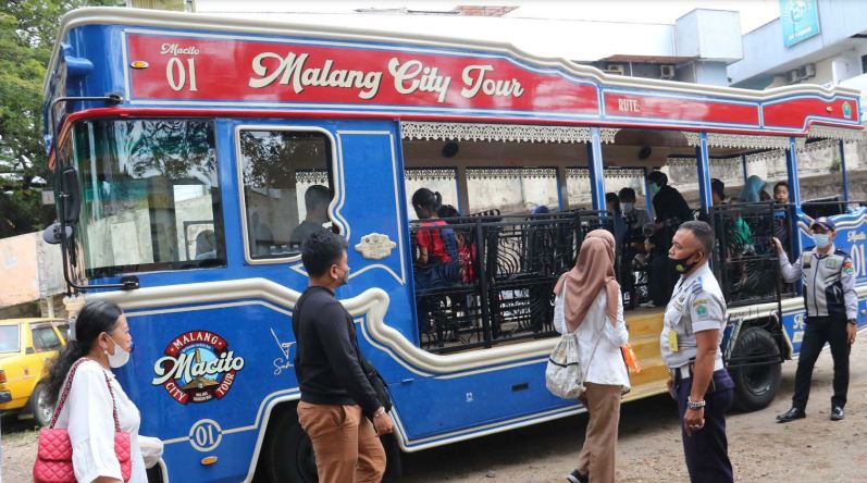 DIMINATI WISATAWAN: Penumpang bus Macito bergiliran masuk kemarin. Dishub mencatat jumlah penumpang bus tersebut selama setahun mencapai 14 ribu orang. Photo By Radar Malang