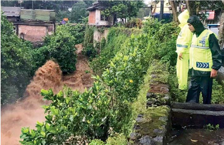 MENGHILANG: Polisi mengamati aliran sungai yang terhubung dengan got tempat menghilangnya Nafisatul Ula di Jalan Wisnuwardhana, Singosari, kemarin (25/1). Photo By Radar Malang
