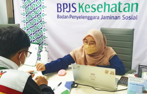 ASURANSI KESEHATAN: Petugas BPJS Kesehatan Cabang  Malang melayani masyarakat. (suharto/radar malang)