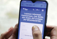 UNTUK PEKERJA: Seseorang membuka program Jaminan Hari Tua (JHT) melalui aplikasi kemarin.