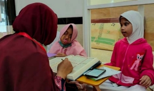 SERIUS: Dua anak penyandang disabilitas belajar mengaji dengan  guru di Masjid Madinah, Kecamatan Lowokwaru kemarin sore (2/1).
