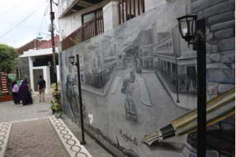TEMPO DULU: Salah satu gang di Kampung Heritage menyuguhkan mural tentang suasana Kota Malang pada zaman kolonial Belanda.
