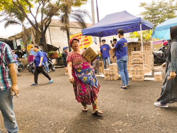 REDAM INFLASI: Seorang ibu membawa minyak goreng yang dibeli dari operasi pasar yang digelar di Pasar Karangploso, kemarin (27/1).