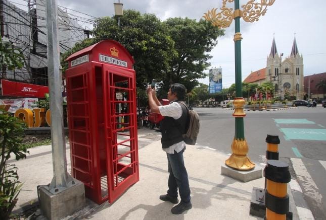 KHAS INGGRIS: Seorang wisatawan mengabadikan kotak telephone berwarna merah di zona tiga Kajoetangan Heritage, Jalan Basuki Rahmat kemarin (3/1).