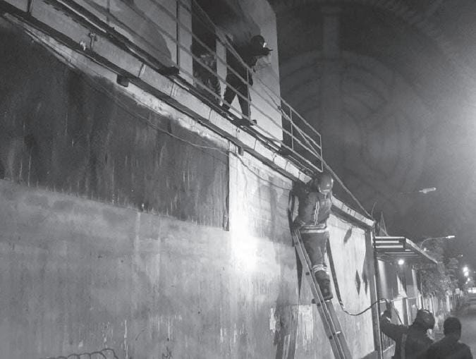 AKIBAT LALAI: Petugas Damkar Kota Malang memanjat tembok untuk memadamkan kebakaran di salah satu kamar rumah kos di Jalan Galunggung, Kelurahan Gading Kasri, Kecamatan Klojen, Selasa malam (10/1). - DAMKAR KOTA MALANG FOR RADAR MALANG